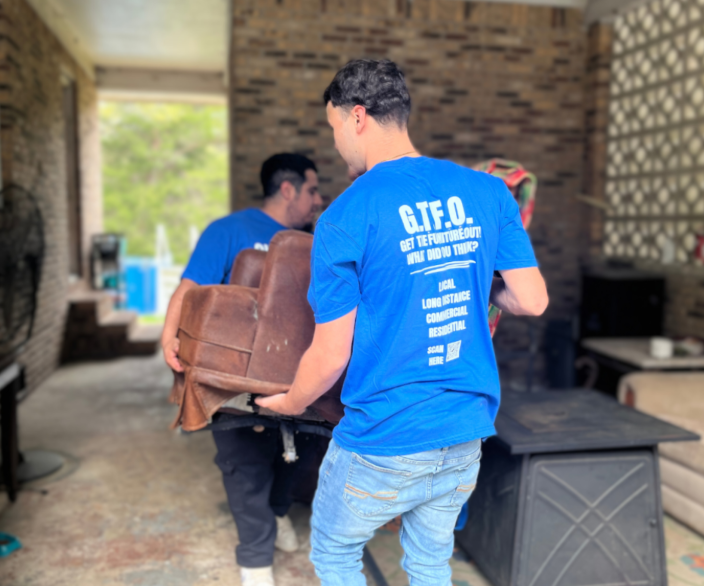 Movers carrying a couch out of a home