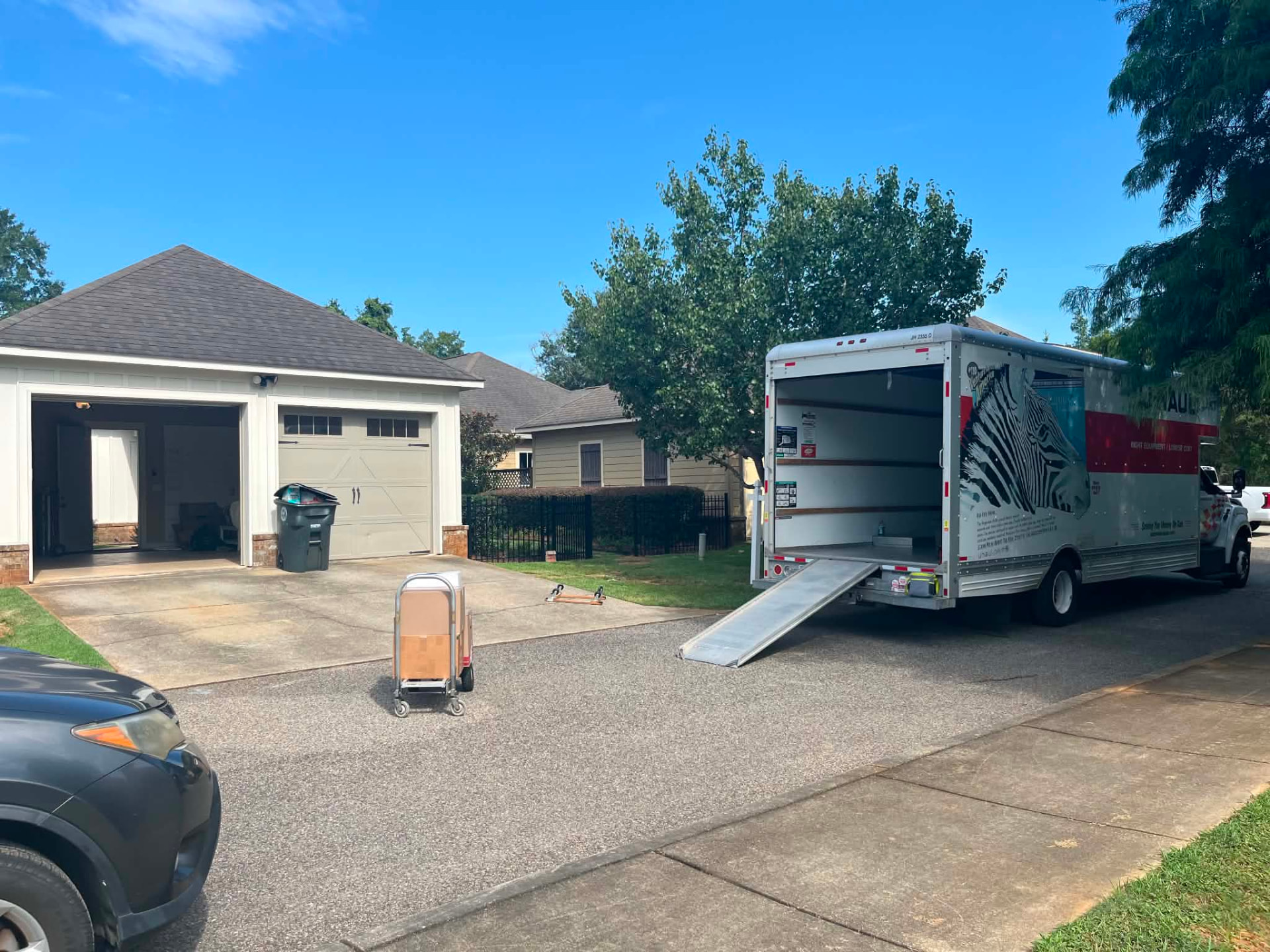 Moving truck with ramp and dolly at a residential home