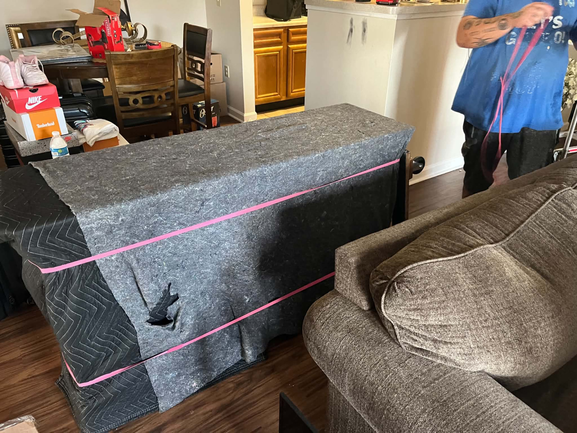 Furniture padded and strapped with moving blankets before transport