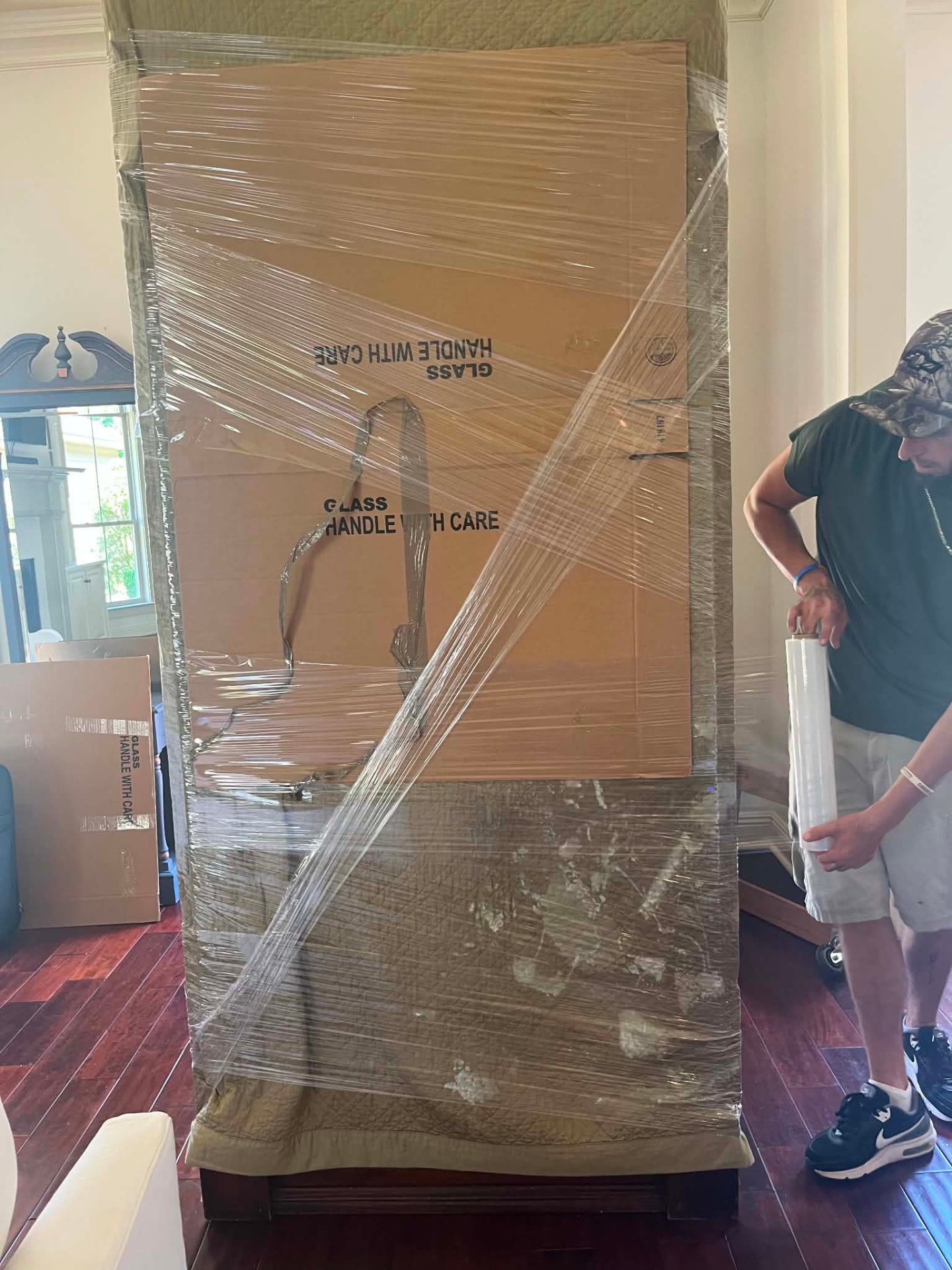 Mover wrapping furniture with plastic for protection